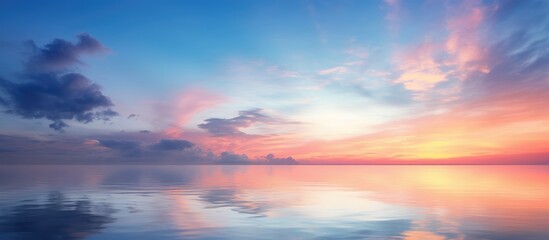 Naklejka na ściany i meble Stunning long exposure of sky at sunrise or sunset with reflected clouds and tropical sea
