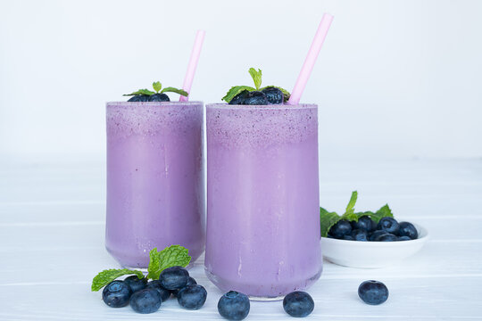 Blueberry Juice smoothies drink in a glass drink purple colorful fruit juice milkshake blend beverage healthy high protein the taste yummy in glass on white wood background.