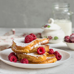 A stack of croutons, toast with raspberries for breakfast with a glass of milk.