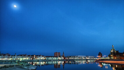 Beautiful buildings on the embankment near the water on the Bruges embankment in Yoshkar-Ola. Cityscape and landscape in the evening