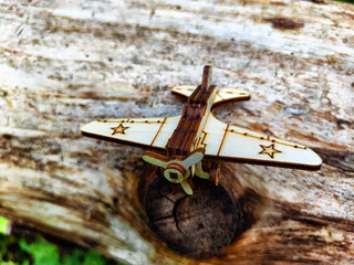 Vintage toy wooden airplane with stars on wing in nature. Plane crash, breakdown. Old Soviet glider...