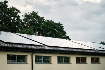 Photovoltaic panels on the roof. Modern house with solar panels. Roof Of Solar Panels. Concept of green energy and sustainable future.