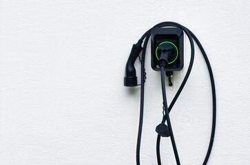 Isolated close-up of wall EV charger. Recharging sustainable transport at home. EV charger in a residential house. Clean power. Future transport technology. - obrazy, fototapety, plakaty