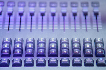 Audio mixing console, closeup of buttons and sliders in studio