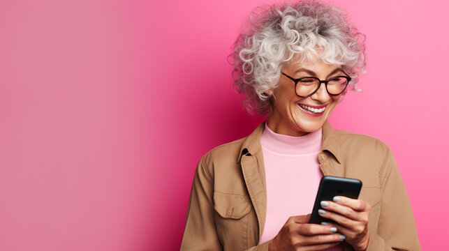 Elderly Women Smiling With Her Phone Against A Color Background. 