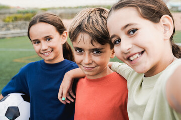 Kid friends after soccer play game having fun taking selfie outside - Latin children celebrating...