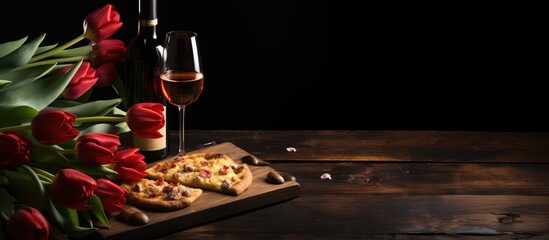 Naklejka na ściany i meble Valentine s Day celebration featuring a heart shaped pizza tulip flowers and wine on a black background