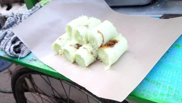 Cinematic shot of traditional Indonesian snacks are usually called Kue Putu. These sweets are made of rice flour and filled with brown sugar, cooked by steaming