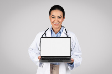 Doctor displaying laptop computer with blank screen for mockup