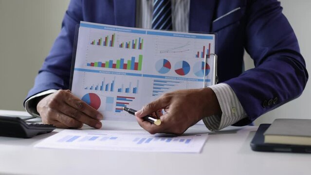 Businessman doing paperwork analyzing financial growth data chart.