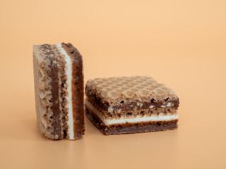 Delicious chocolate waffles with hazelnuts on an orange background. Wafers with chocolate and nuts.