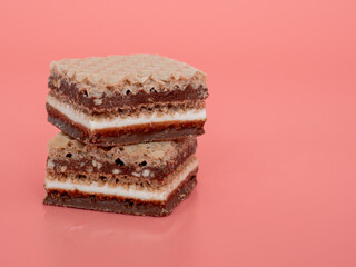 Delicious chocolate wafers with hazelnuts on a pink background. Wafers with chocolate and nuts.