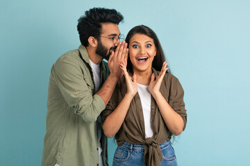 Middle eastern guy sharing secret with his excited pretty girlfriend