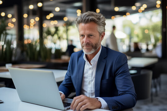 Mature business manager efficiently multitasks on laptop for various tasks 