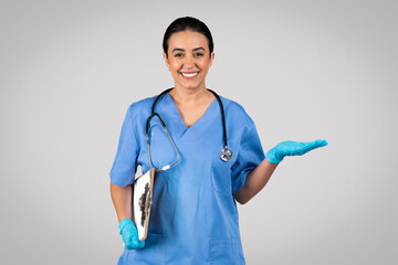 Doctor in blue uniform holds clipboard, presenting something on her palm