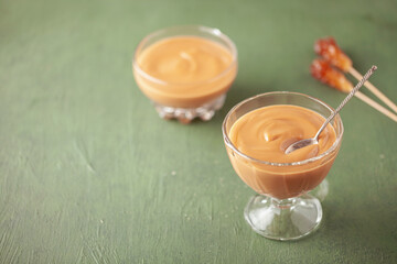 Homemade butterscotch pudding in glass cream bowl on the table. National Butterscotch Pudding Day