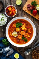 Louisiana soup gumbo with shrimp, chorizo and white rice on wooden table 