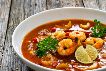 Louisiana soup gumbo with shrimp, chorizo and white rice on wooden table 