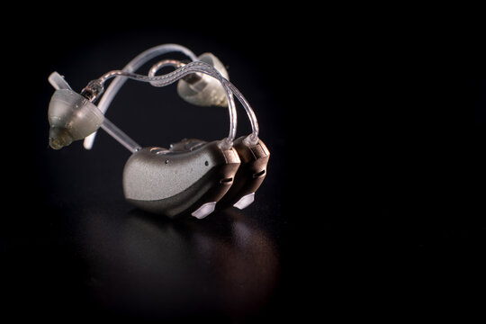 hearing aids stand on a black background next to each other