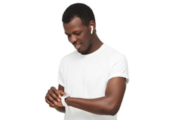 Young african american man checking smartwatch, wearing wireless earphones and blank white t-shirt