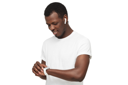 Young african american man checking smartwatch, wearing wireless earphones and blank white t-shirt