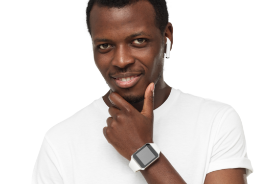 Young african american man looking at camera, showing smartwatch with blank screen, wearing wireless earphones and blank white t-shirt
