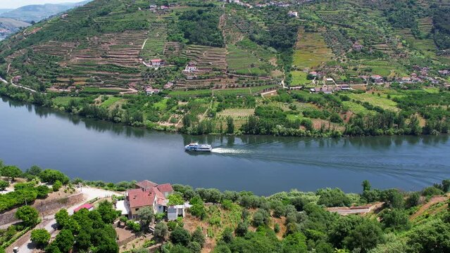 Aerial Flyover above River  boat cruise cruising down the Douro River in the Douro Valley Portugal