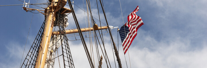 Panoramic image. American flag on the mast of a sailing ship
