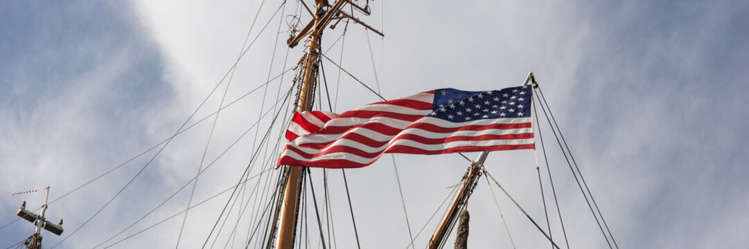 Panoramic image. American flag on the mast of a sailing ship