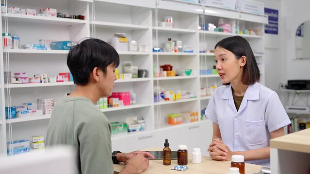 Beautiful asian female pharmacist analyzing about customer symptoms for discussion of the medicine property effect and customer buying pill under prescription order. 4k resolutions.