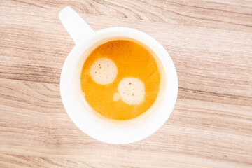 Espresso with a crema top in a white cup top down view