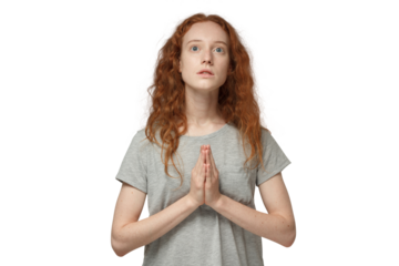 Religious young redhead woman praying to god, pressing palms together, looking up