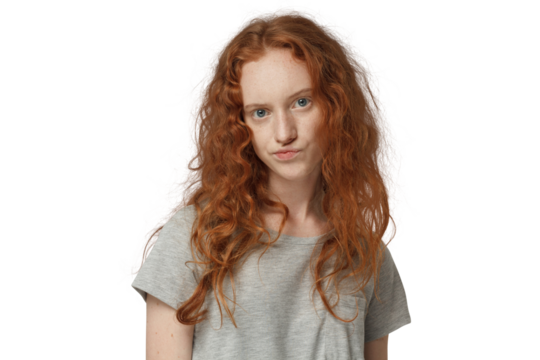 Portrait of young redhead woman, her lips twisted in sign of disagreement, doubt and mistrust