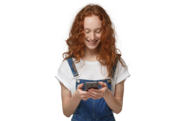 Young redhead woman looking at phone while holding phone with both hands