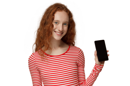 Portrait of smiling to camera young redhead woman showing blank phone with black screen - Powered by Adobe