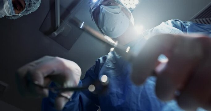 Team, doctors and below in surgery, operation theater and healthcare clinic. Group, surgeon and medical tools for collaboration in emergency room, treatment of people and hands working on lens flare