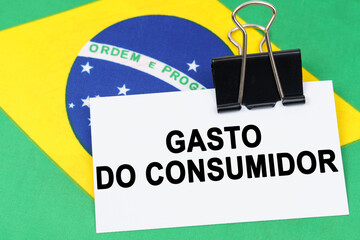 On the flag of Brazil lies a business card with the inscription - Consumer spending