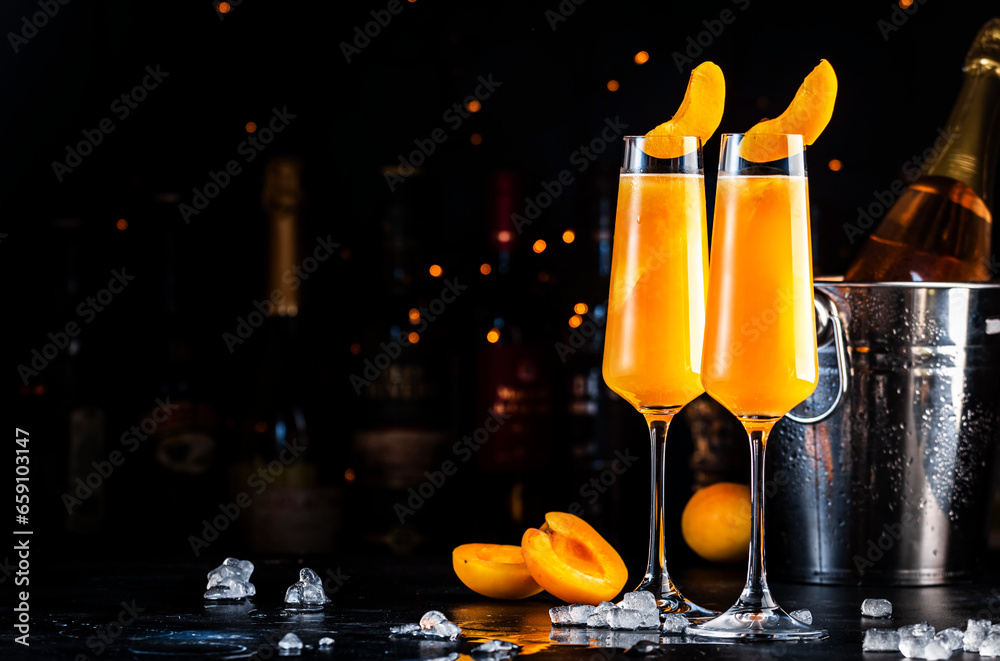 Wall mural apricot bellini cocktail drink with sparkling wine and apricot puree, syrup and ice, dark bar counte