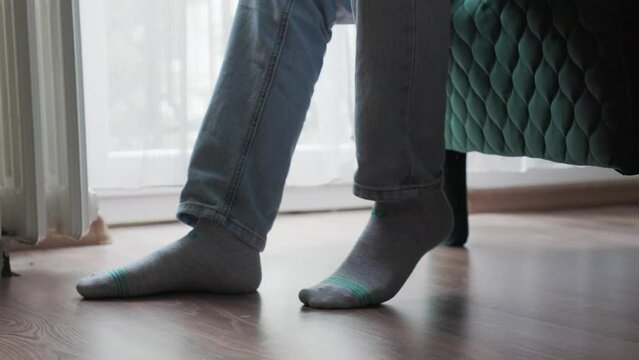 Person is sitting in chair and nervously shaking his leg. Close-up. Concept of nervous reflexes and mental health problems