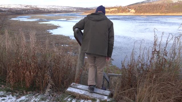 Utsjoki, Finland A man walks on stairs leading down to the Karasjohka River on the border between Finland and Norway in the winter. 