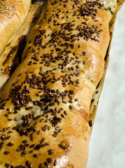 Meat pies. Baked rolls from yeast dough, sprinkled with sesame and flax seeds on parchment.