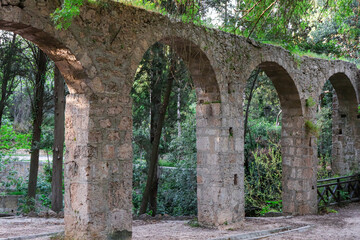 Fototapeta na wymiar Aqueduct, a watercourse arch over the Rodini Park lake and walking path located in central Rhodes