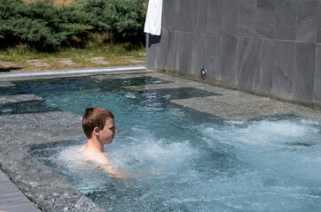 teenage boy relaxing in an outdoor thermal complex