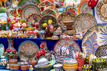 Ornate colorful oriental dishes and ceramics on market window. Silk Road