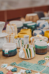 Obraz na płótnie Canvas handmade ceramics, empty craft ceramic plates, mug, cup and bowls at a street fair or flea market or street Sunday market. Selective focus.