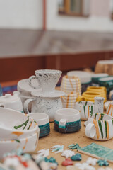 handmade ceramics, empty craft ceramic plates, mug, cup and bowls at a street fair or flea market or street Sunday market. Selective focus.