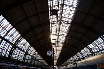 Morning sun rays penetrating through the roof and illumination empty raylway station, selective focus