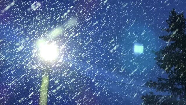 Falling snow in the light. Flying snow on a dark blue background. Snow-covered sky. Snow movement in 4K format. The view of falling snow against the light of a glowing lantern at night.