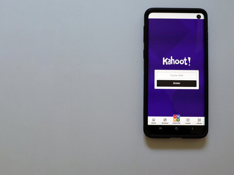 Harish, Israel - June 10 2021: Kahoot app launch screen with logo on the display of a black mobile smartphone isolated on white background. Top view flat lay with copy space.