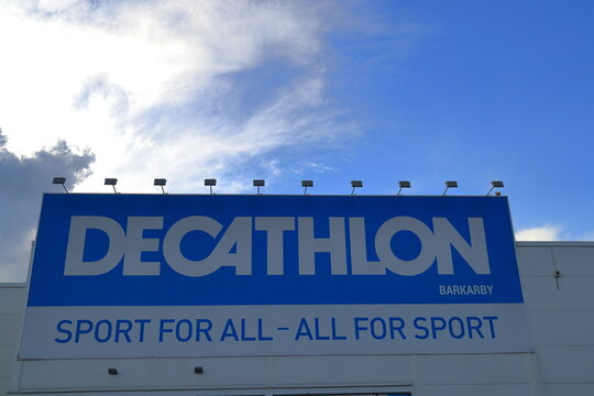 A large sign for the company Decathlon. Nice sky in the background a summer day. Blue and white picture or photo.